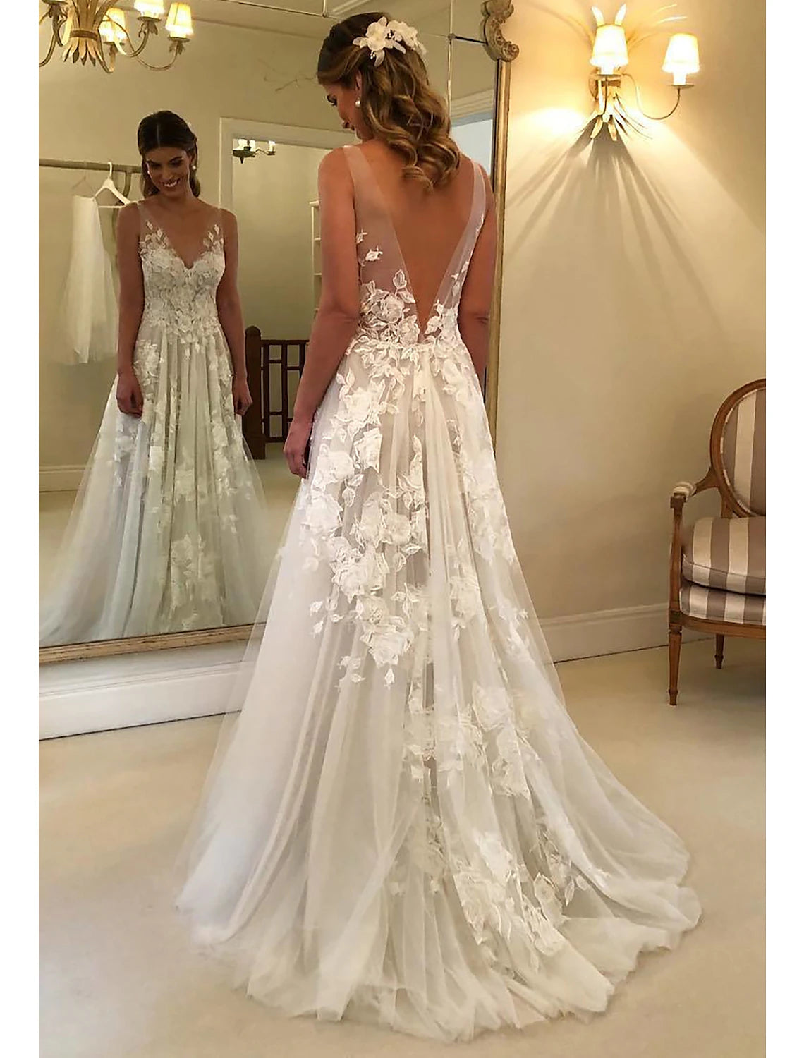 Ivory A-line bridal gown featuring V-neck, sleeveless lace bodice, appliques, and sweep train