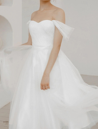 Tea-length white A-line dress in chiffon with ruched off-the-shoulder detailing