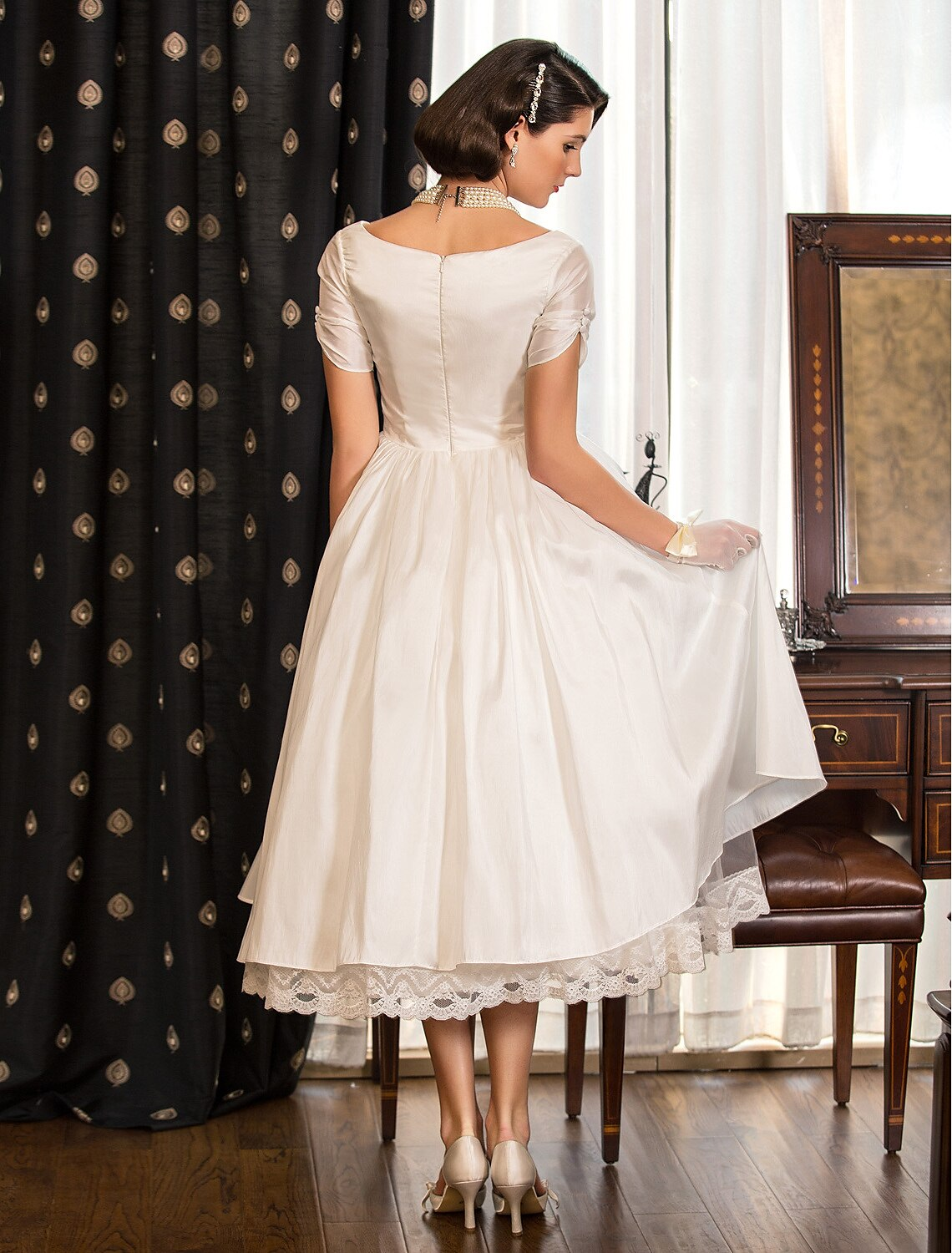 A-line tea length satin wedding dress with V-neckline and lace criss cross detail