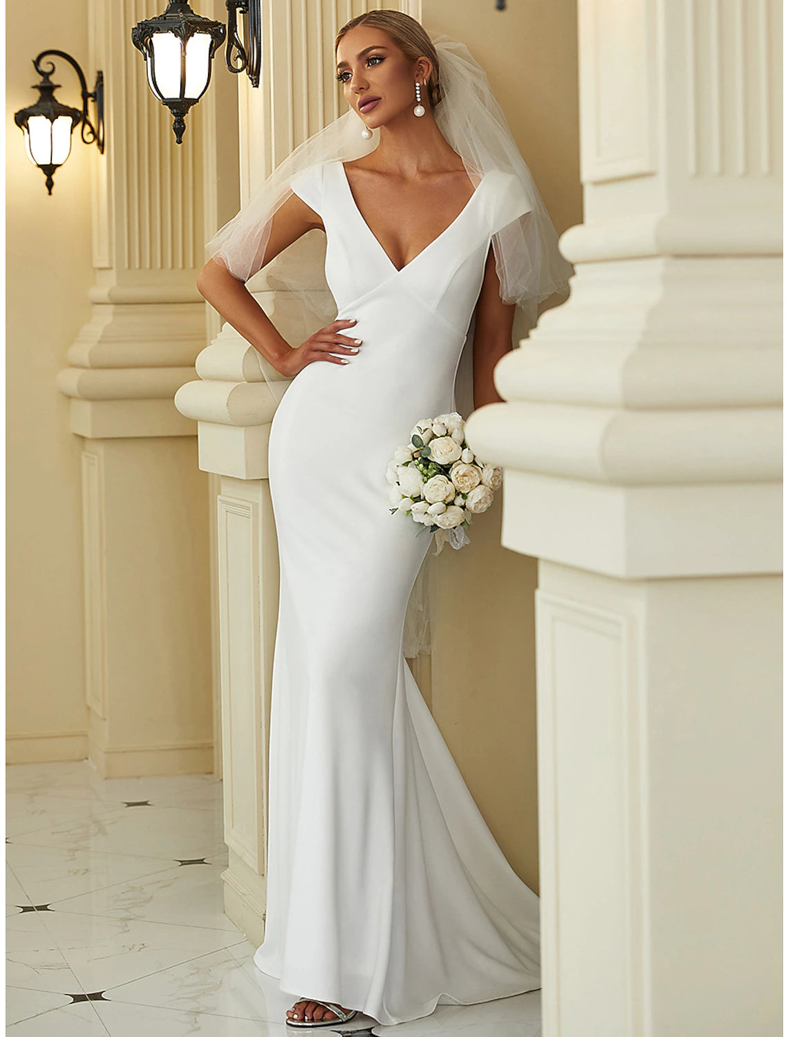 Solid white cap sleeve mermaid bridal gown with V-neck and draped stretch fabric