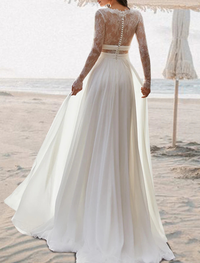 Back view of boho chiffon beach wedding dress showcasing the open back and floor-length pleated skirt