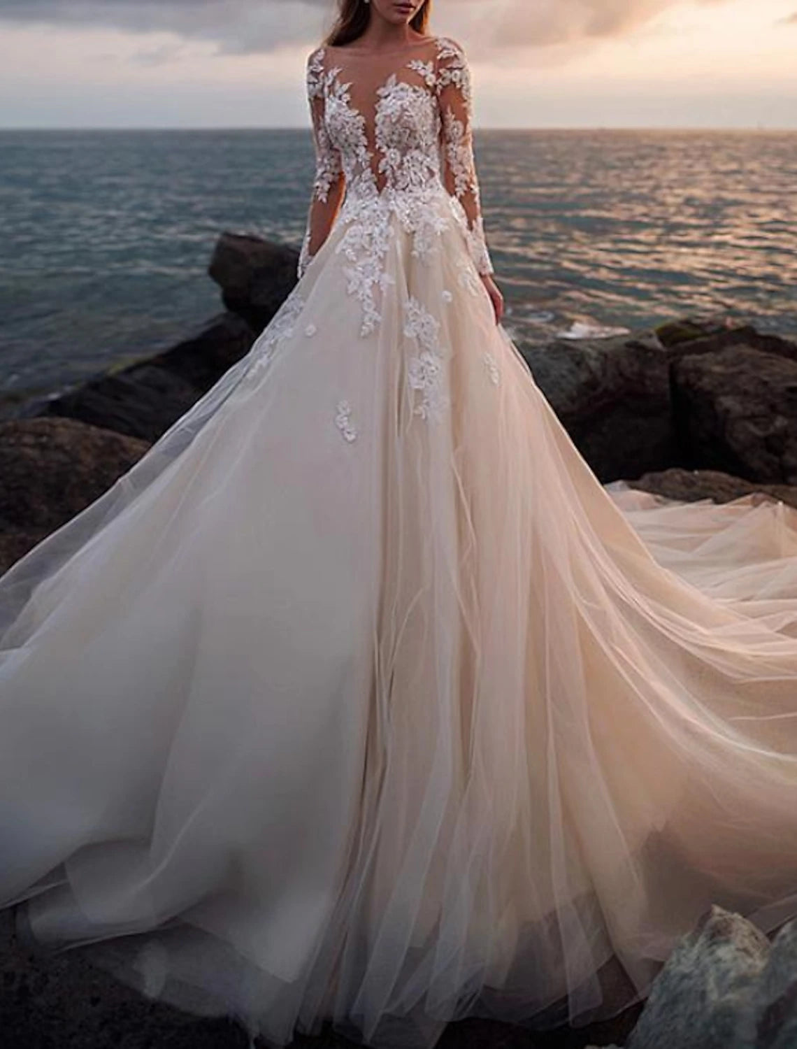 A-line white wedding dress designed with illusion neck, long sleeves, and court train