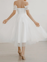White chiffon tea-length bridal gown with off-the-shoulder neckline and ruched bodice
