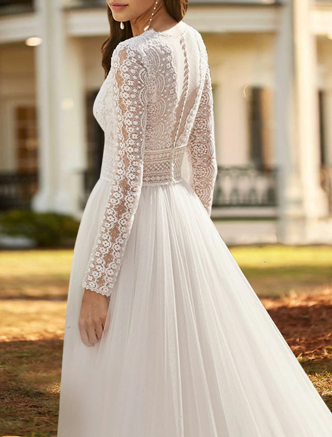 Ivory A-line lace wedding dress with V-neck, long sleeves, front split, and court train