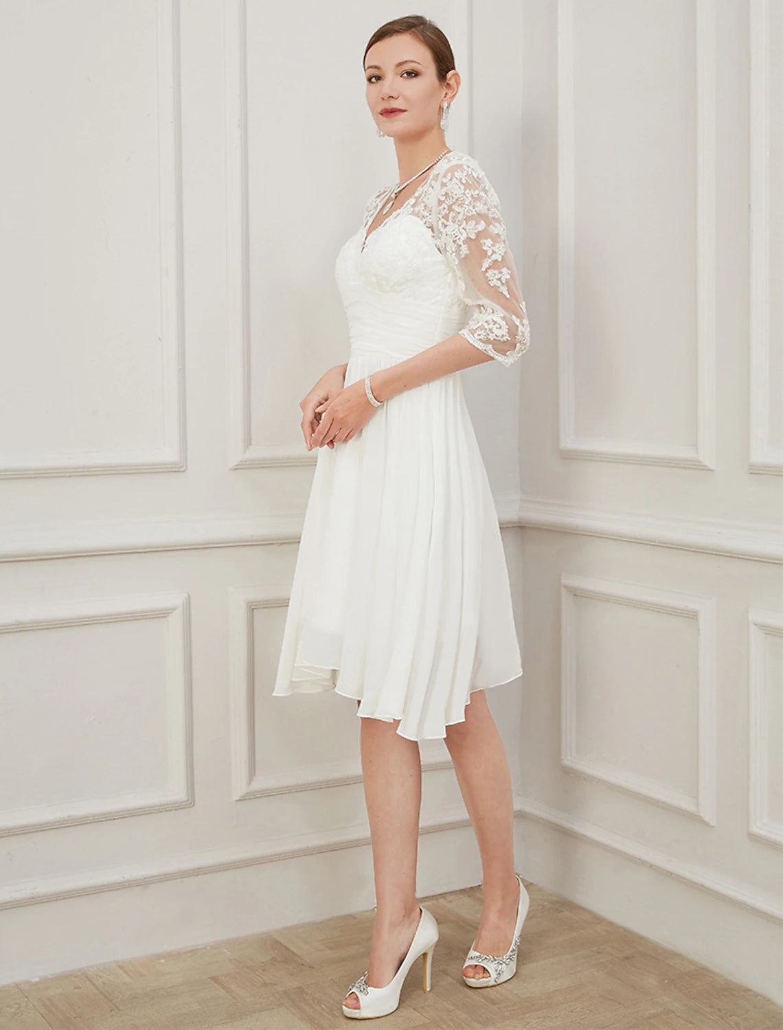 Back view of Ivory knee-length chiffon wedding dress with draping and applique accents