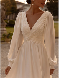 Solid color ivory chiffon bridal gown with sleeveless camisole bodice and pleats