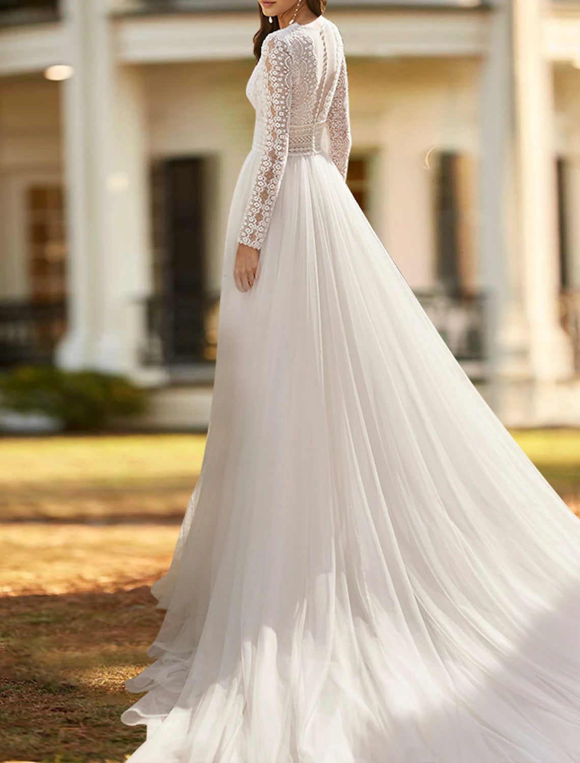 Ivory A-line lace bridal gown featuring a V-neckline, long sleeves, and split front