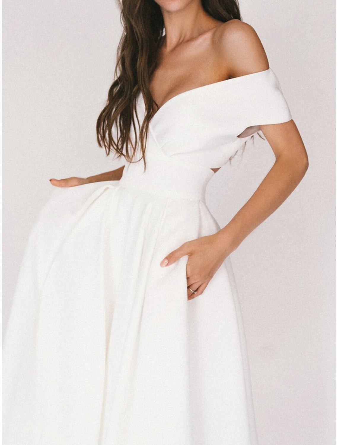 Side view of Ivory tea-length A-line chiffon wedding dress with pleats and V-neckline