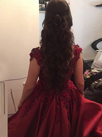 Side view of burgundy sleeveless off-the-shoulder applique satin ball gown