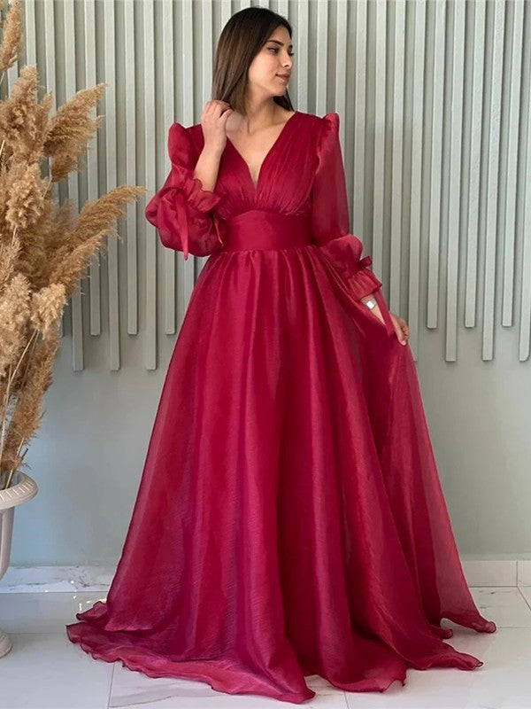 A-line organza prom dress featuring ruched V-neck bodice, long sleeves, and sweep train