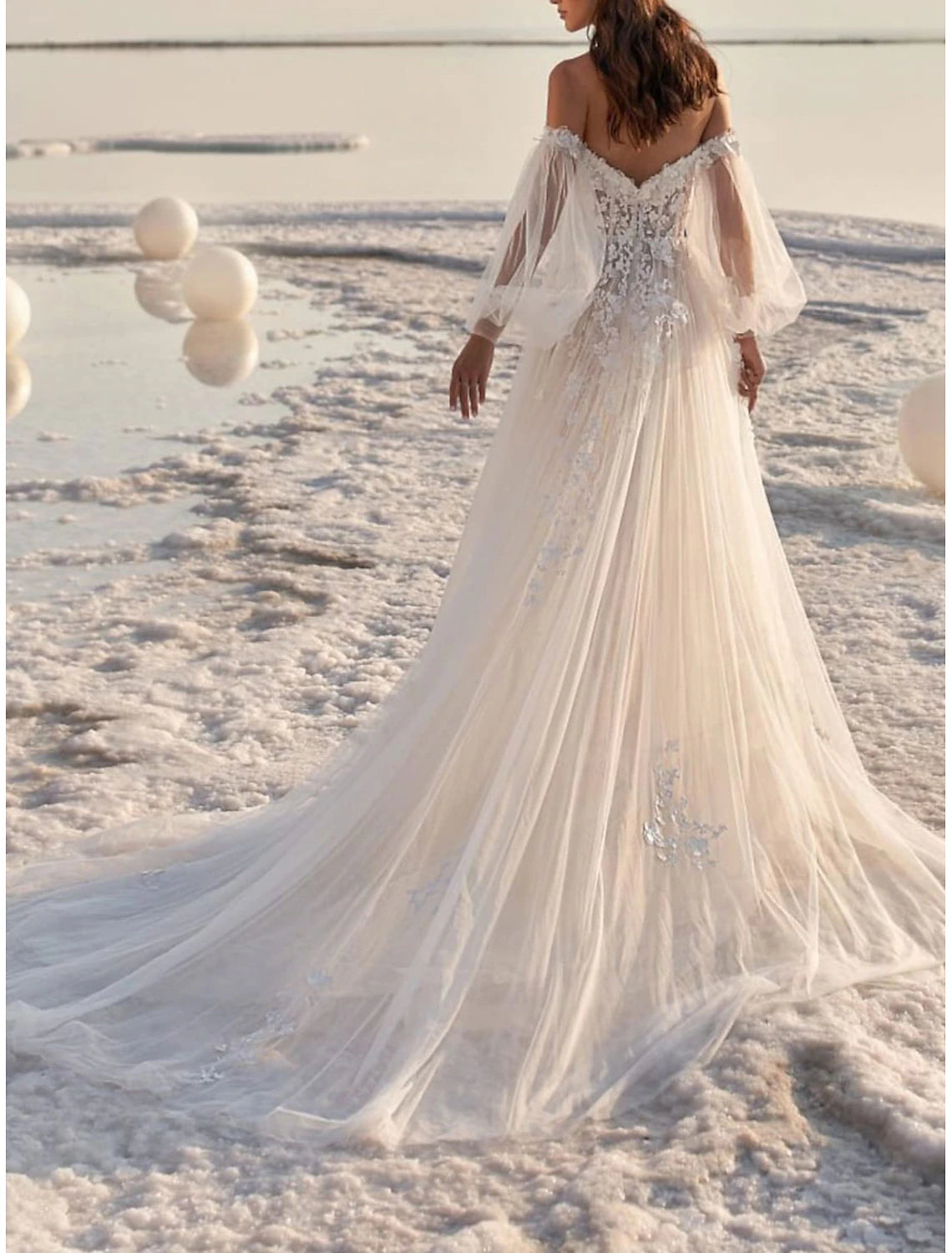 A-line lace bridal gown featuring off-shoulder neckline, long sleeves, appliques, and court train