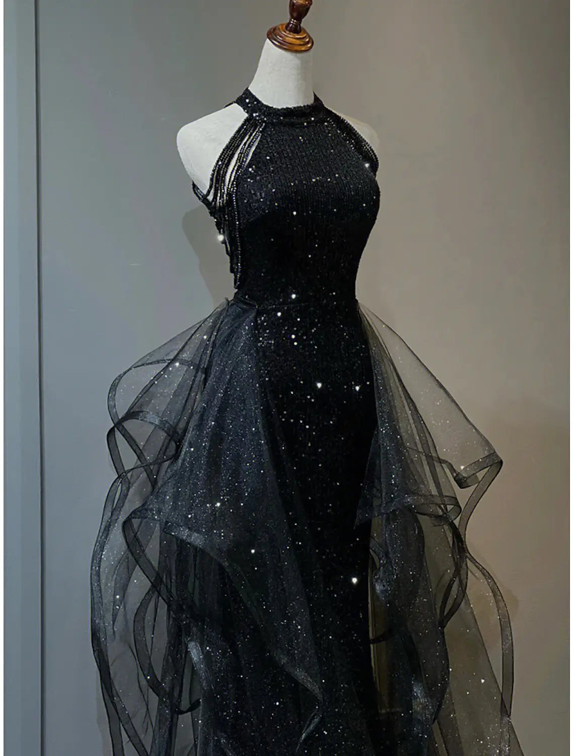 Close-up of sequined fabric with crystals and sequin ruffles on halter neck prom dress