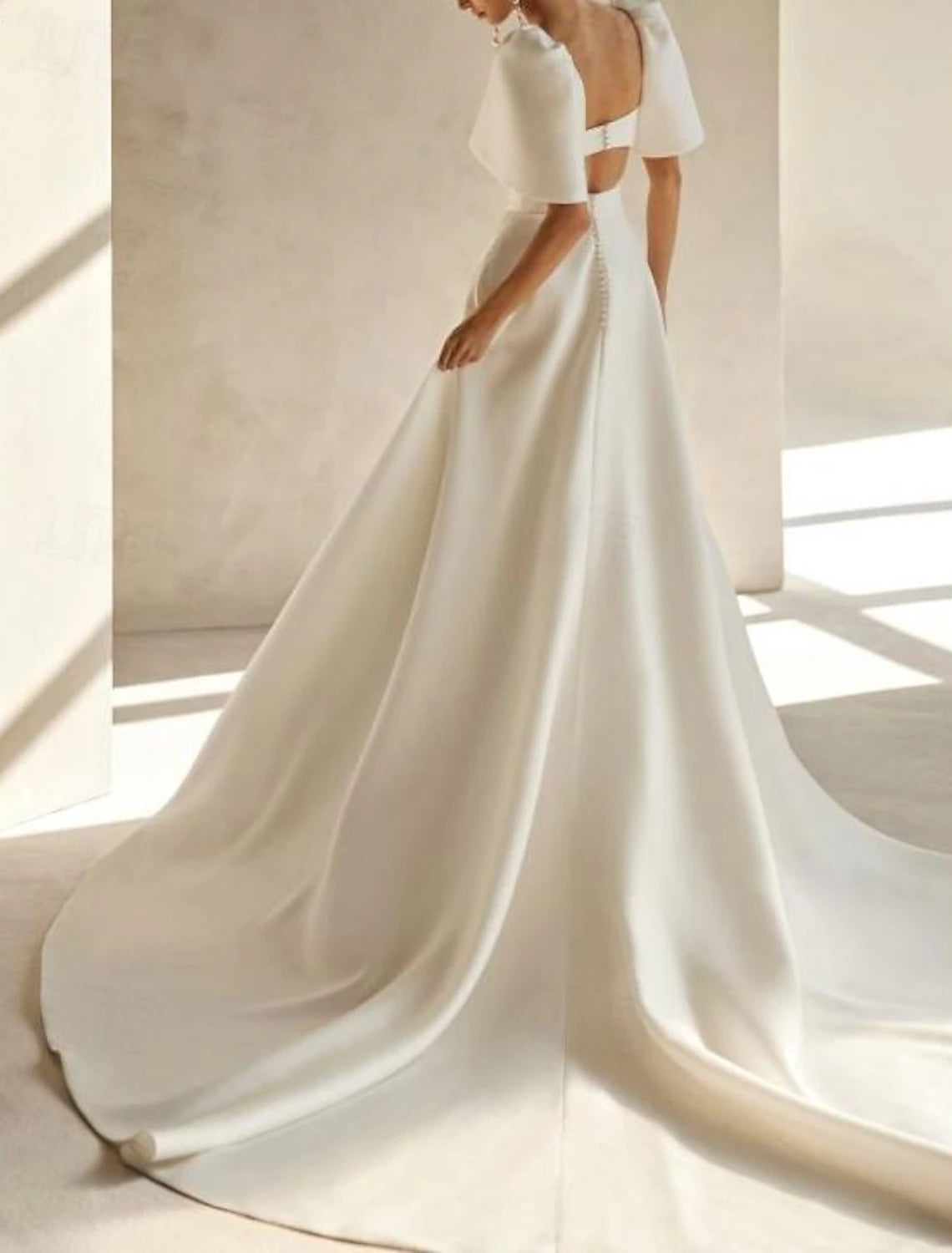White satin bridal gown featuring square neck, short sleeves, and chapel train