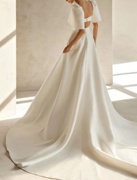 White satin bridal gown featuring square neck, short sleeves, and chapel train
