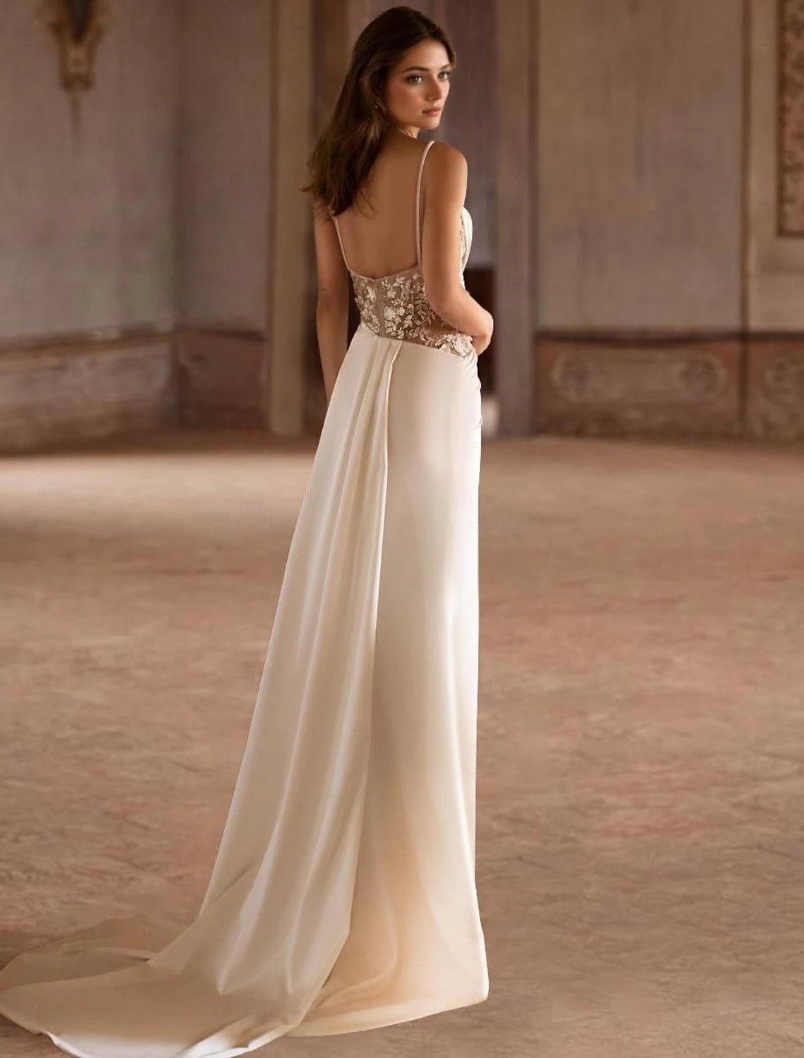 Ivory A-line satin wedding gown featuring spaghetti straps and a sweep / brush train