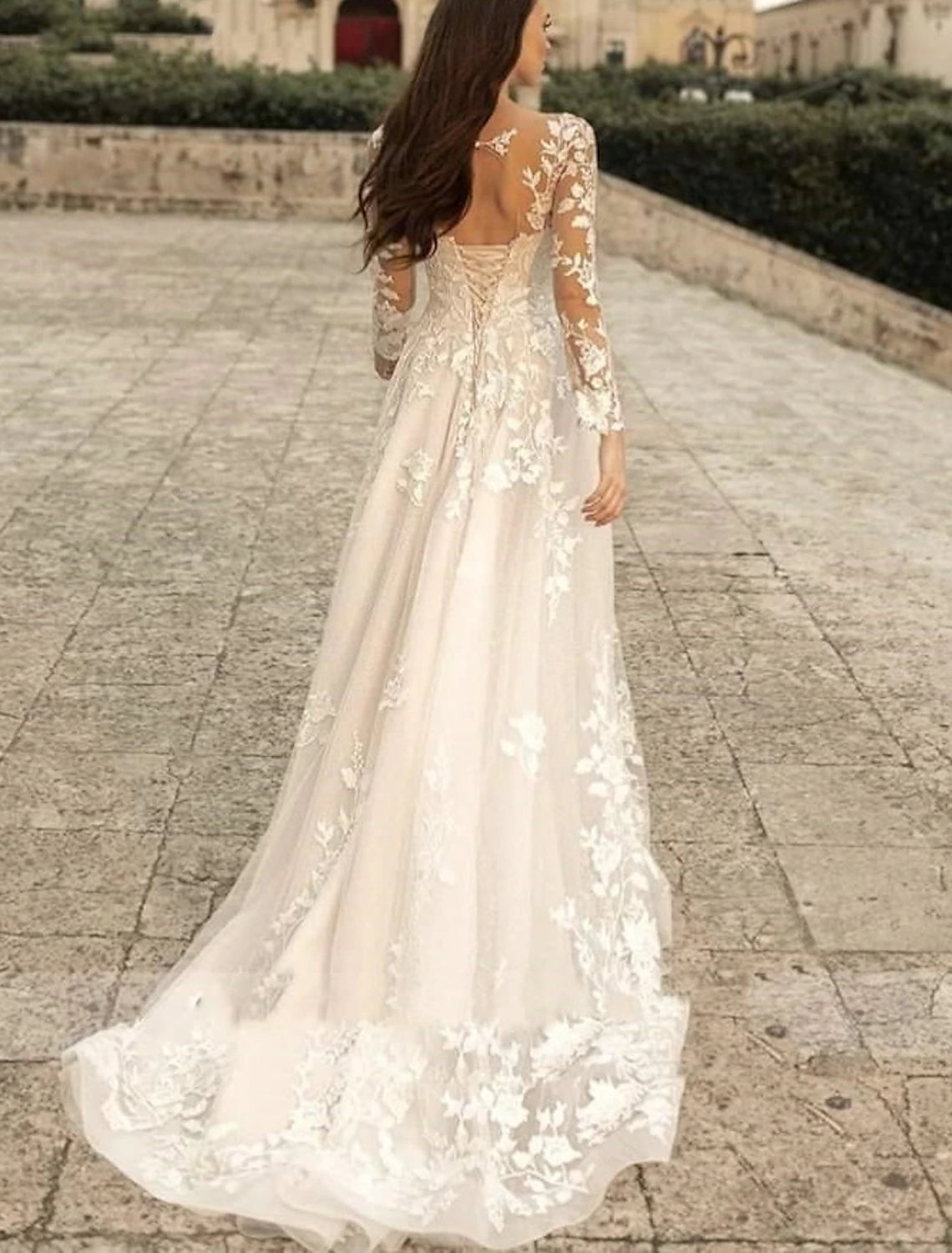 Close-up of lace fabric and floral accents on solid color bridal gown