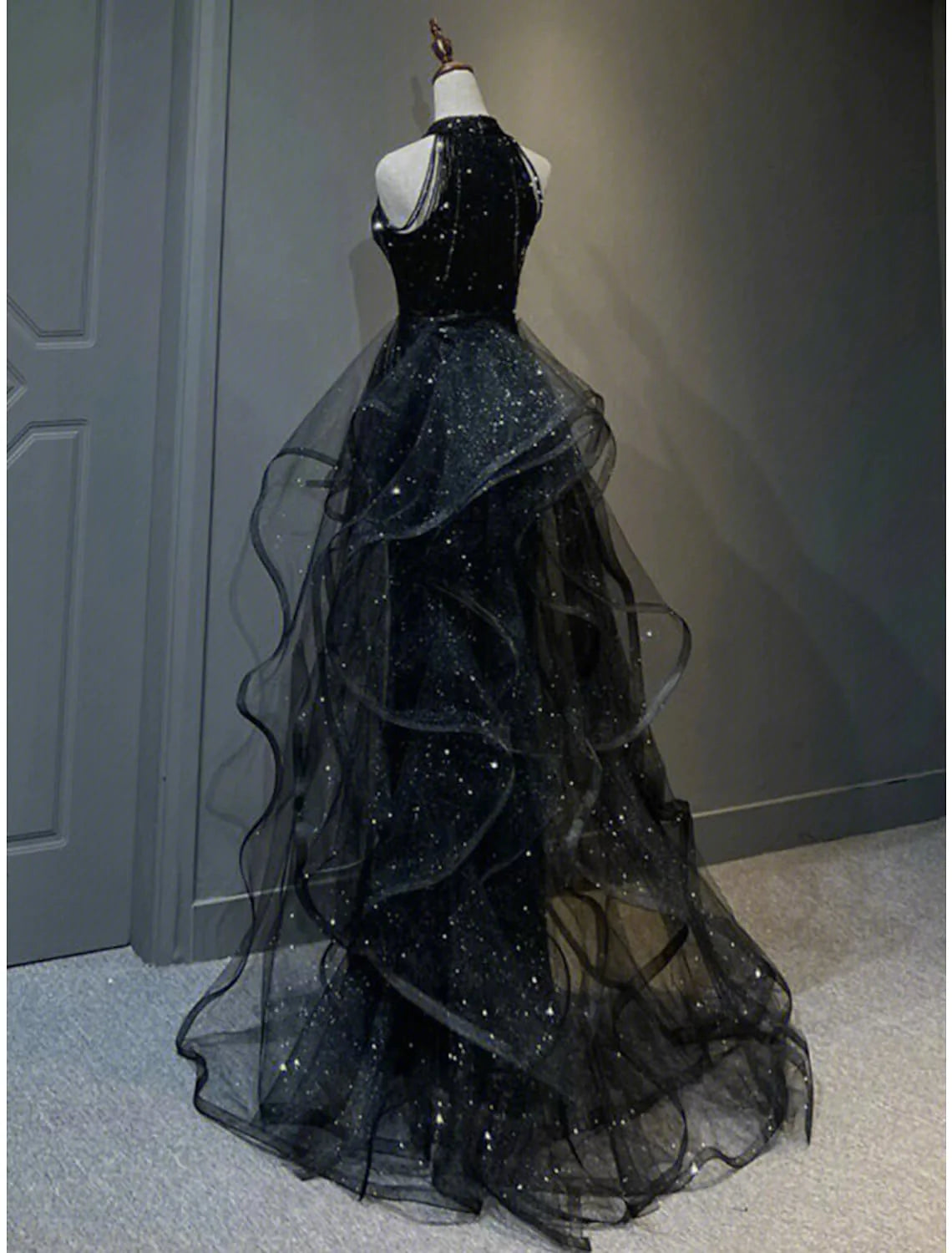 Back view of sleeveless halter neck A-line sequined prom dress with sweep train