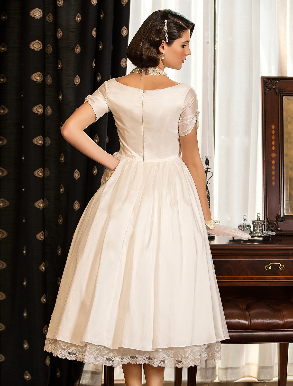 Ivory satin bridal gown with tea length A-line skirt and short sleeves