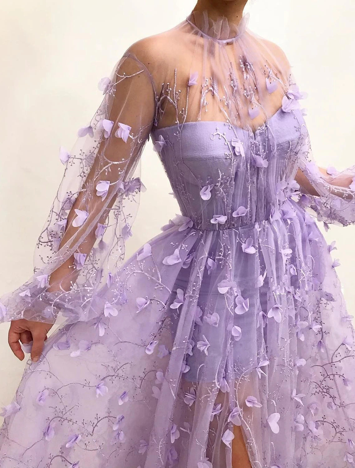 Detail of V-neckline, long sleeves, and floral appliques on tulle A-line prom dress