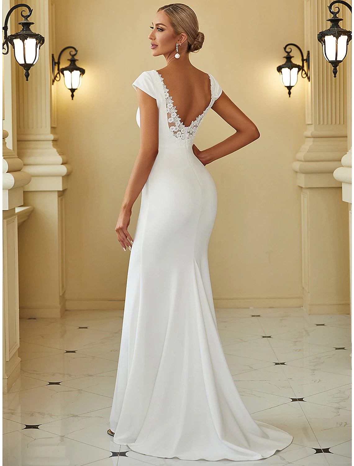 White stretch fabric mermaid wedding gown featuring bodice draping and sweep brush train