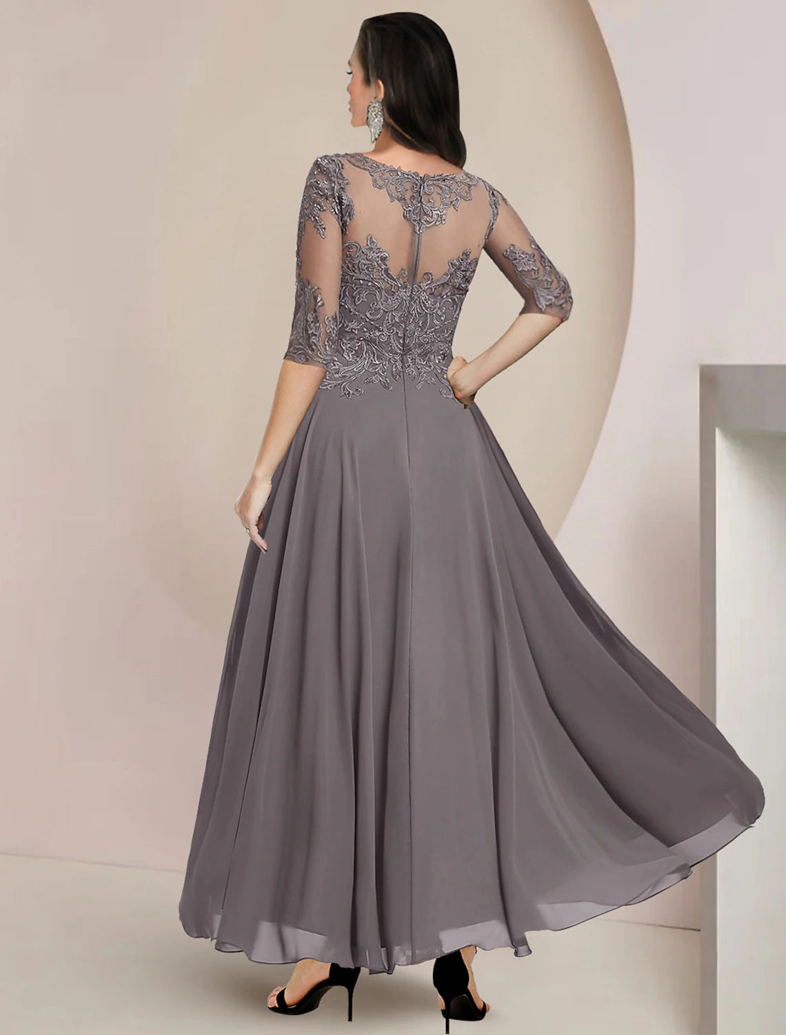 Pleated A-line mother of the bride dress featuring lace appliques and high-low hem