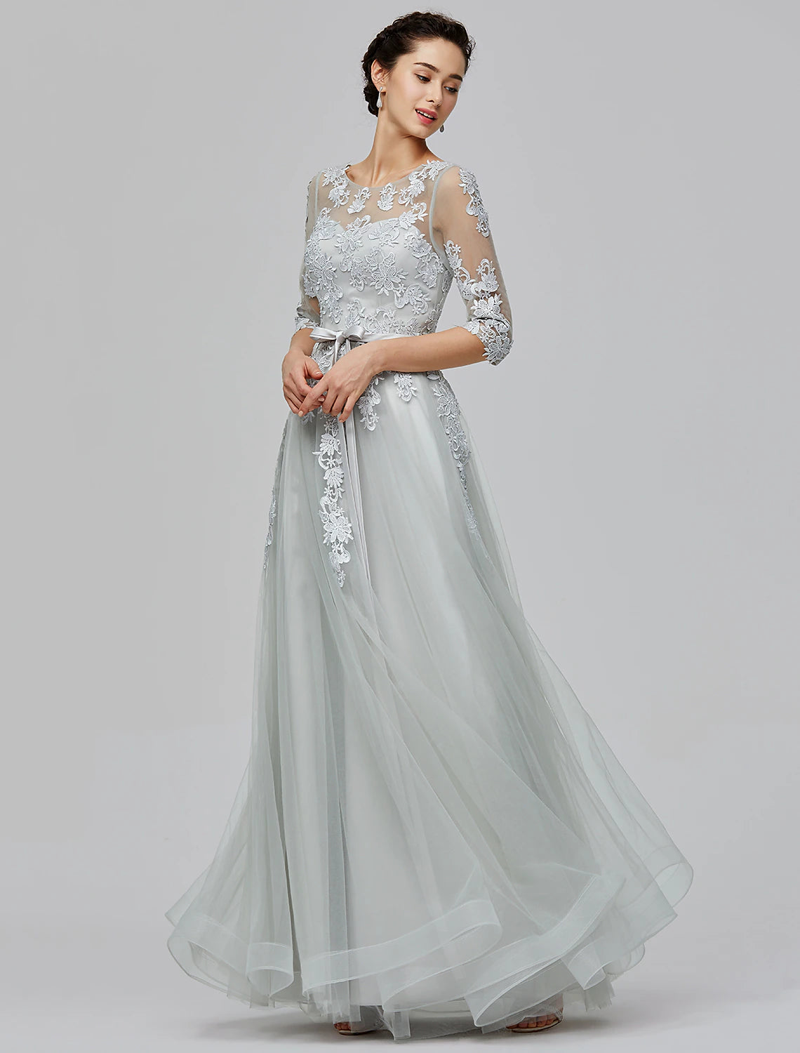 Illusion neck A-line empire evening gown in silver tulle with half sleeves and bow details