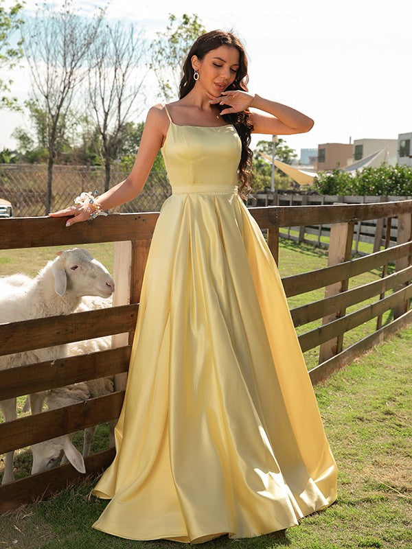 A-line satin prom dress featuring ruffles, spaghetti straps, and sweep brush train
