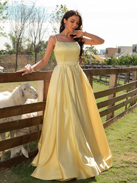 A-line satin prom dress featuring ruffles, spaghetti straps, and sweep brush train